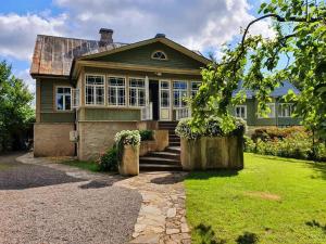 a large green house with a porch and a yard at Väike-Liiva Villa in Haapsalu