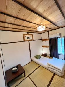 a small room with a bed and a table at Bighem Maison in Izumi-Sano