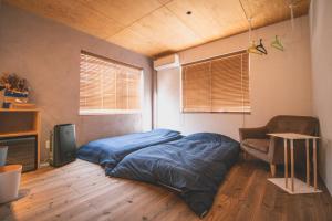 um quarto com uma cama e uma cadeira em Camellia Complex em Inawashiro