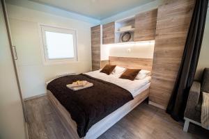 um quarto com uma cama e uma parede de madeira em Premium Mobile Tree House with Thermal Riviera Tickets em Catez ob Savi
