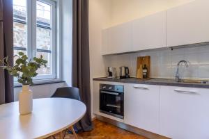 a kitchen with white cabinets and a table and a window at Amazing studio in the city center + WiFi in Trieste