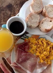 two plates of food with eggs and bread and a glass of juice at B&B Napul'è in Naples +4 photos