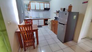 a kitchen with a refrigerator and a table and chairs at Manava Tahara'a Home Stay in Mahina