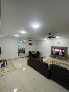 a living room with couches and a flat screen tv at Hadeerna Homestay - Double storey terrace in Chemor