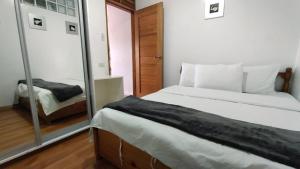 a bedroom with two beds and a mirror in it at RiCio Haus in Baguio