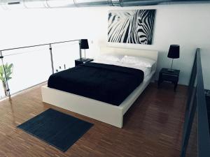 アルカラ・デ・エナレスにあるLoft Confortのベッドルーム1室(ベッド1台付)が備わります。壁にシマウマの絵画が飾られています。