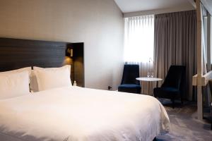 a hotel room with a bed and a chair at Pillows Grand Boutique Hotel Reylof Ghent in Ghent