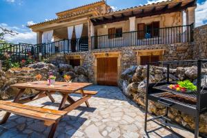 a patio with a table and a grill and a house at Almadrava - La Caseta in Port de Pollensa