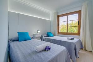 two beds in a room with a window at Ideal Property Mallorca - Cittadini 37 in Alcudia