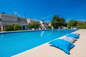 een zwembad met blauwe kussens naast een gebouw bij Ideal Property Mallorca - Avus in Alcudia