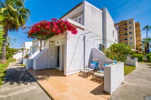 a white house with flowers on a patio at Ideal Property Mallorca - Avus in Alcudia