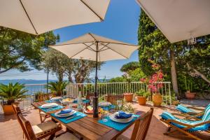 a wooden table with an umbrella on a patio at Ideal Property Mallorca - Bell Punt in Alcanada