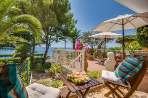 a patio with a table and chairs and an umbrella at Ideal Property Mallorca - Bell Punt in Alcanada