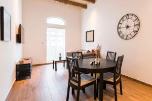 a dining room with a table and a clock on the wall at Valletta Collection - 101 Republic in Valletta