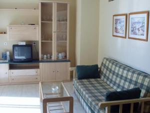 a living room with a couch and a tv at Apartamentos Pueblo Salado in Puerto de Mazarrón