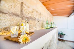 a counter with glasses and bottles and a flower on it at Ca na Serrieta in Alcudia