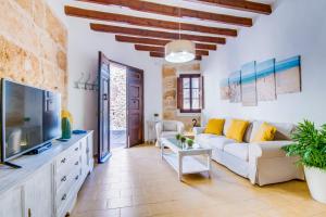 un salon avec un canapé blanc et une télévision dans l'établissement Ideal Property Mallorca - Ca na Serrieta, à Alcúdia