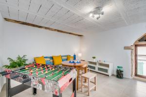 - un salon avec une table de baby-foot et des chaises dans l'établissement Ideal Property Mallorca - Ca na Serrieta, à Alcúdia
