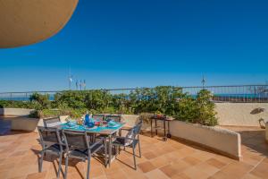 a table and chairs on a patio with the ocean in the background at Ideal Property Mallorca - Ca sa Tati in Son Serra de Marina