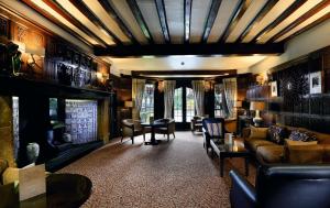 a living room filled with furniture and a large window at Macdonald Alveston Manor Hotel & Spa in Stratford-upon-Avon