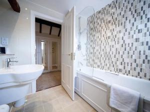 a bathroom with a tub, toilet and sink at Macdonald Alveston Manor Hotel & Spa in Stratford-upon-Avon
