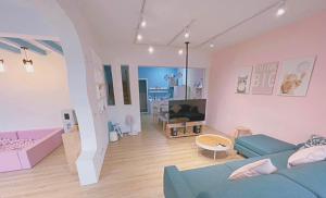 een woonkamer met een blauwe bank en een tv bij 李家出走民宿 in Sanzhi