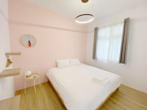 een slaapkamer met een wit bed en een raam bij 李家出走民宿 in Sanzhi