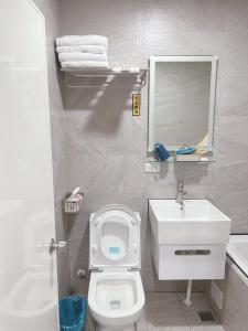 een badkamer met een wit toilet en een wastafel bij Benz 賓士溫泉旅館 in Jiaoxi