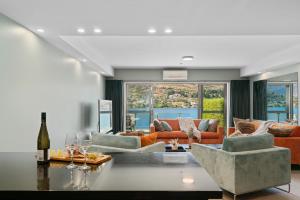a living room with couches and a table at Lake Front 3-bedroom Apartment with Lake Access in Queenstown
