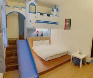 1 dormitorio con 1 cama y un tobogán azul en Mulin B&B en Hengchun