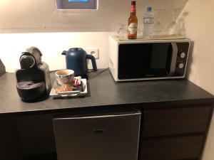 a kitchen counter with a microwave and a cup of coffee at Lait & Lit in Triqueville