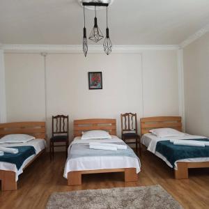 um quarto com duas camas com cadeiras e um tapete em Leila's Guest House em Joqolo