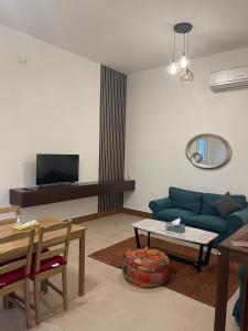 sala de estar con sofá azul y mesa en 2 Bedroom Villa in Ras Al Khaimah with Privat swimming Pool, en Ras al Khaimah