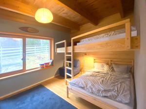 a bedroom with a bunk bed and a window at Family Lodge for 13 guests, fireplace, lakeview, sauna, hot tube in Brzozie