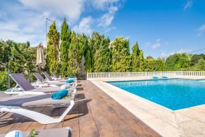 uma fila de espreguiçadeiras junto a uma piscina em Ideal Property Mallorca - Can Mesilla em Santa Margalida