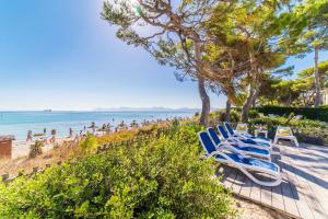 grupa niebieskich leżaków na plaży w obiekcie Ideal Property Mallorca - Gaviotas w Playa de Muro