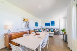 jadalnia i salon z białym stołem i krzesłami w obiekcie Ideal Property Mallorca - Gaviotas w Playa de Muro