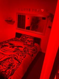 a red bedroom with a bed with a red bedspread at love love 23 in Villeurbanne
