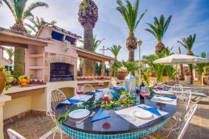 a patio with a table and chairs and a fireplace at Can Comaro in Alcudia