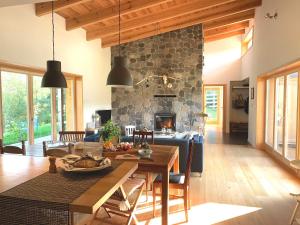 a living room with a table and a fireplace at Family Lodge for 13 guests, fireplace, lakeview, sauna, hot tube in Brzozie