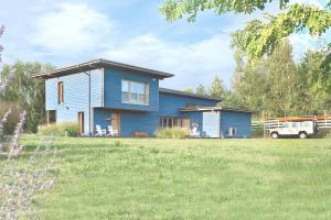 a blue house with a truck in a yard at Family Lodge for 13 guests, fireplace, lakeview, sauna, hot tube in Brzozie