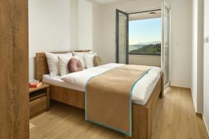 a bedroom with a large bed with a large window at Sun Spalato Residence in Makarska