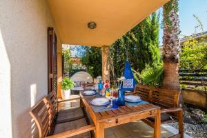 einen Holztisch und Stühle auf einer Terrasse in der Unterkunft Ideal Property Mallorca - Luca in Alcúdia