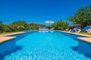 una piscina con sillas y sombrilla en Ideal Property Mallorca - Mamici en Capdepera