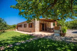 een stenen huis met een patio en een tuin bij Ideal Property Mallorca - Mamici in Capdepera