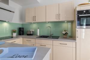 a kitchen with white cabinets and a sink at Strandresidenz in Börgerende-Rethwisch