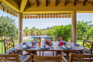 a wooden table on a porch with a tableclotholitics at Ideal Property Mallorca - Mestre in Selva