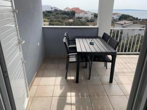 a table and chairs on a balcony with a view of the ocean at D&W Mandre 34 in Mandre