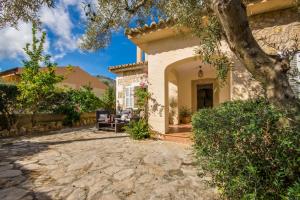 una casa con una pasarela de piedra que conduce a un patio en Ideal Property Mallorca - Can Olivo, en Puerto de Alcudia