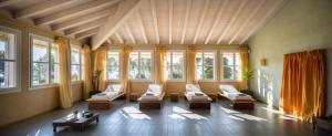 a large living room with white chairs and windows at Hotel Caesius Thermae & Spa Resort in Bardolino
